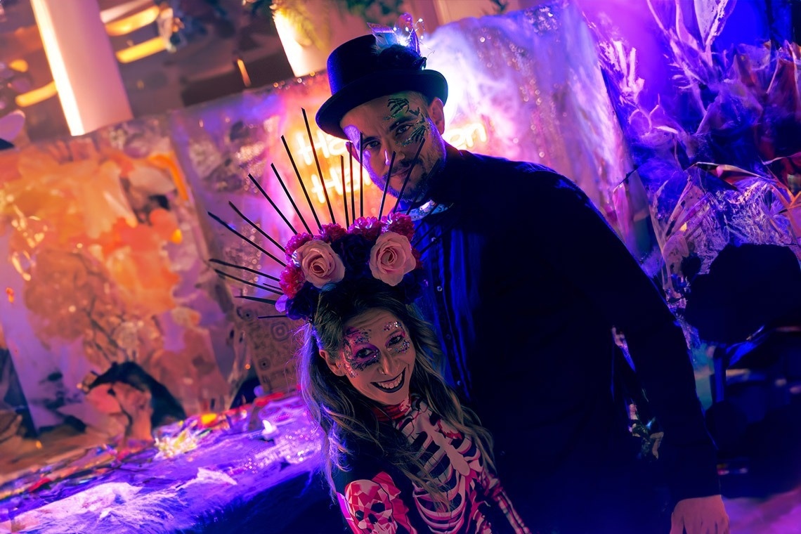 a man in a top hat is standing next to a woman in a skeleton costume