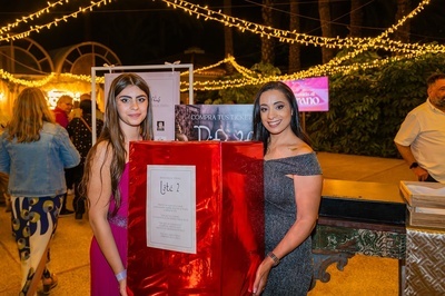 dos mujeres sostienen una caja roja que dice lote 2 - 