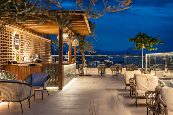 un grupo de personas están sentadas en sillas y mesas en un patio al aire libre
