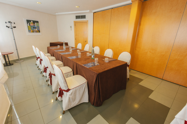 una sala de conferencias con mesas y sillas y una pantalla