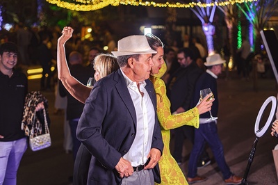 un hombre y una mujer bailan en una fiesta mientras la mujer sostiene una copa de vino - 