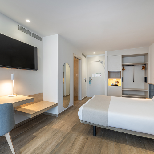 una habitación de hotel con una cama y una televisión