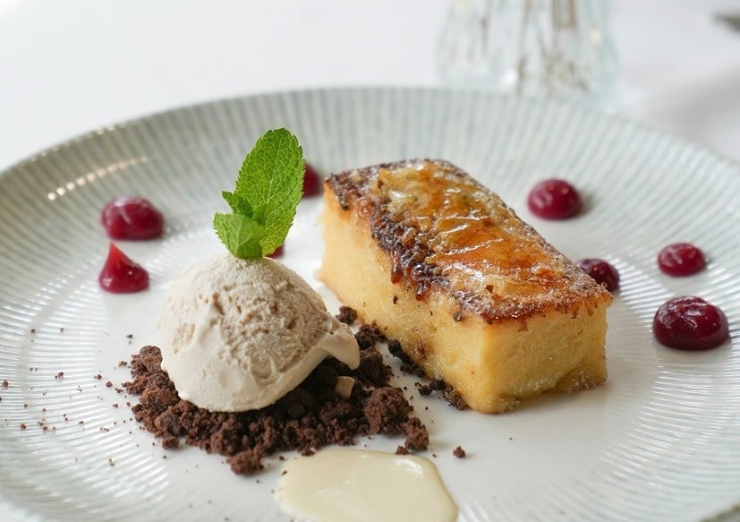 a dessert with ice cream and berries on a white plate