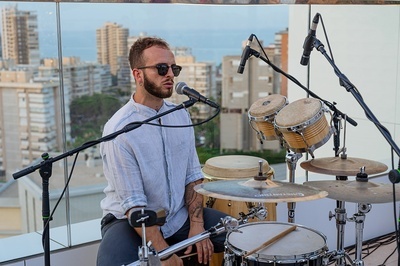 a man singing into a microphone while playing drums - 