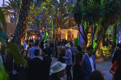 a crowd of people are gathered in a lush green forest - 