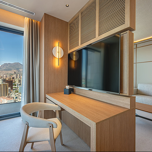 Port Hotels: Corporativa: Sofá y mesa de centro de diseño moderno en suite de hotel con vistas a la ciudad.