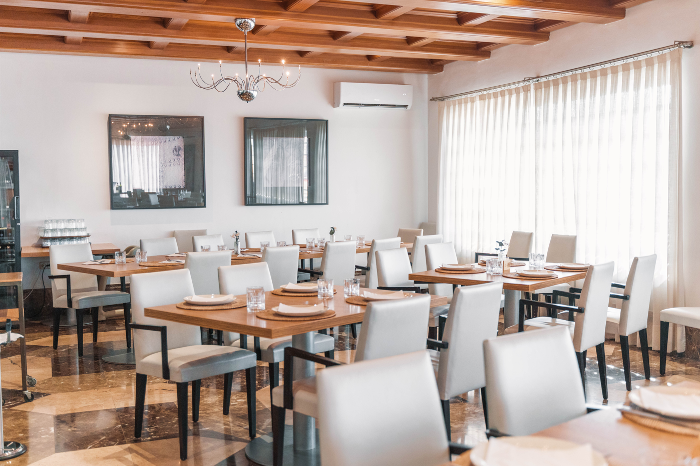 un restaurante lleno de mesas y sillas con un suelo de mármol