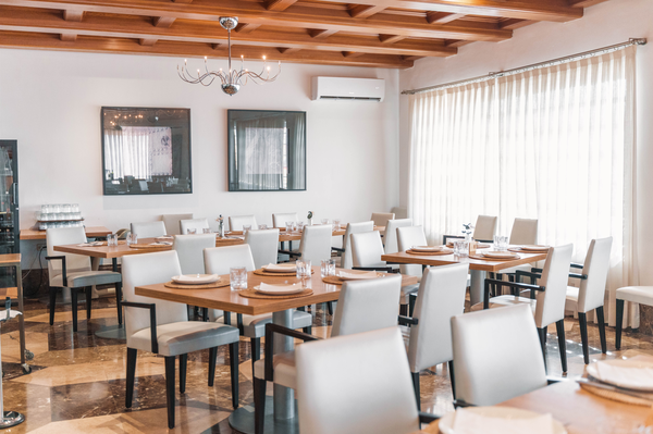 un restaurante lleno de mesas y sillas con un suelo de mármol