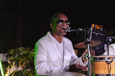 a man singing into a microphone while playing drums - 