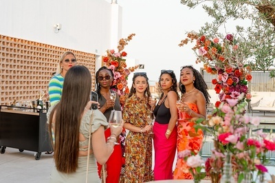 a woman taking a picture of a group of women drinking champagne - 