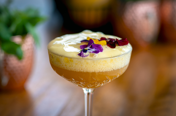 un grupo de personas están sentadas en sillas y mesas en un patio al aire libre