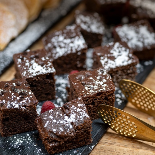 a tray of brownies with powdered sugar on top