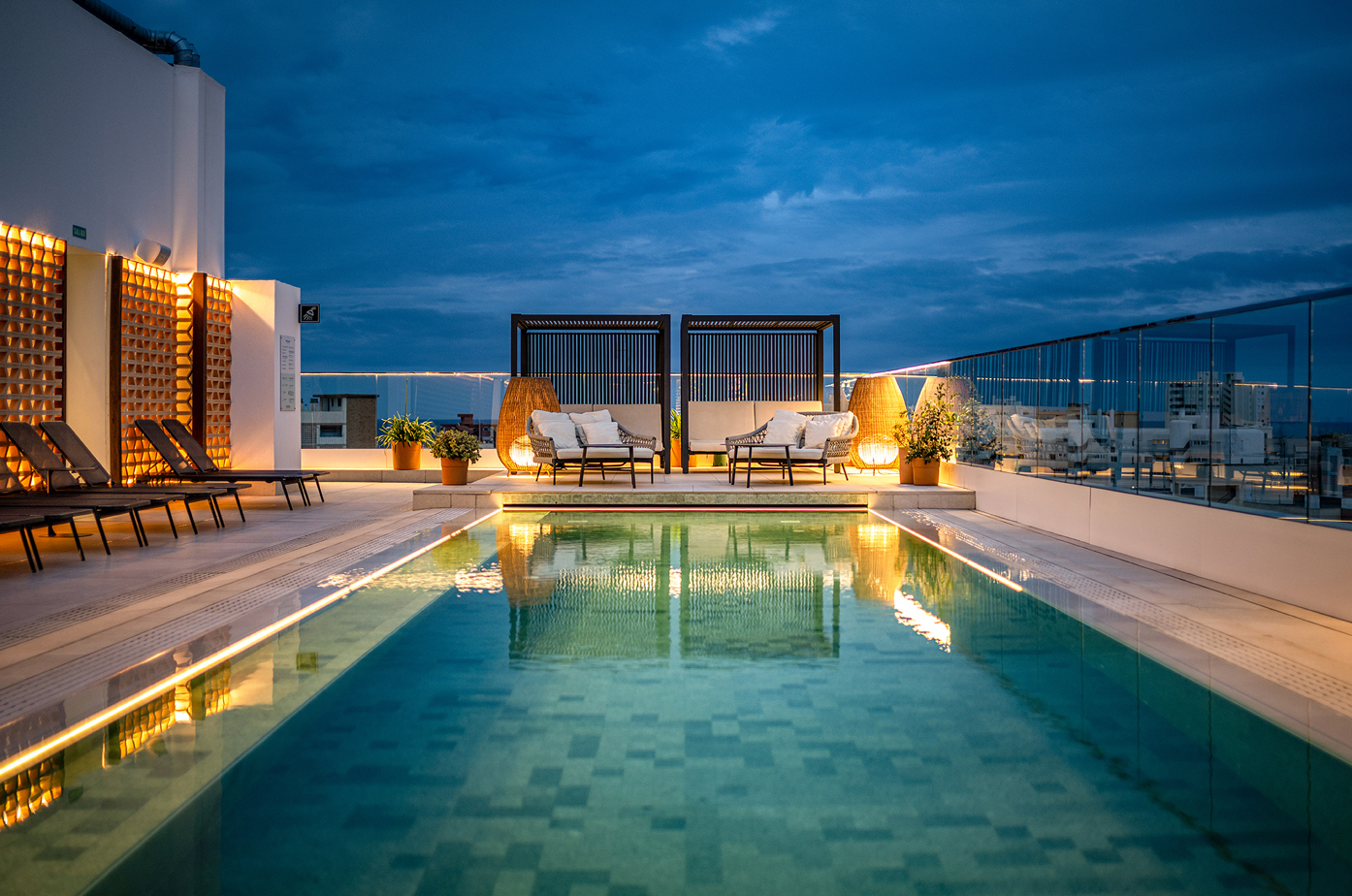 una piscina en la azotea de un edificio con muebles alrededor