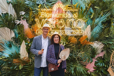 a man and woman standing in front of a sign that says bienvenido al verano - 