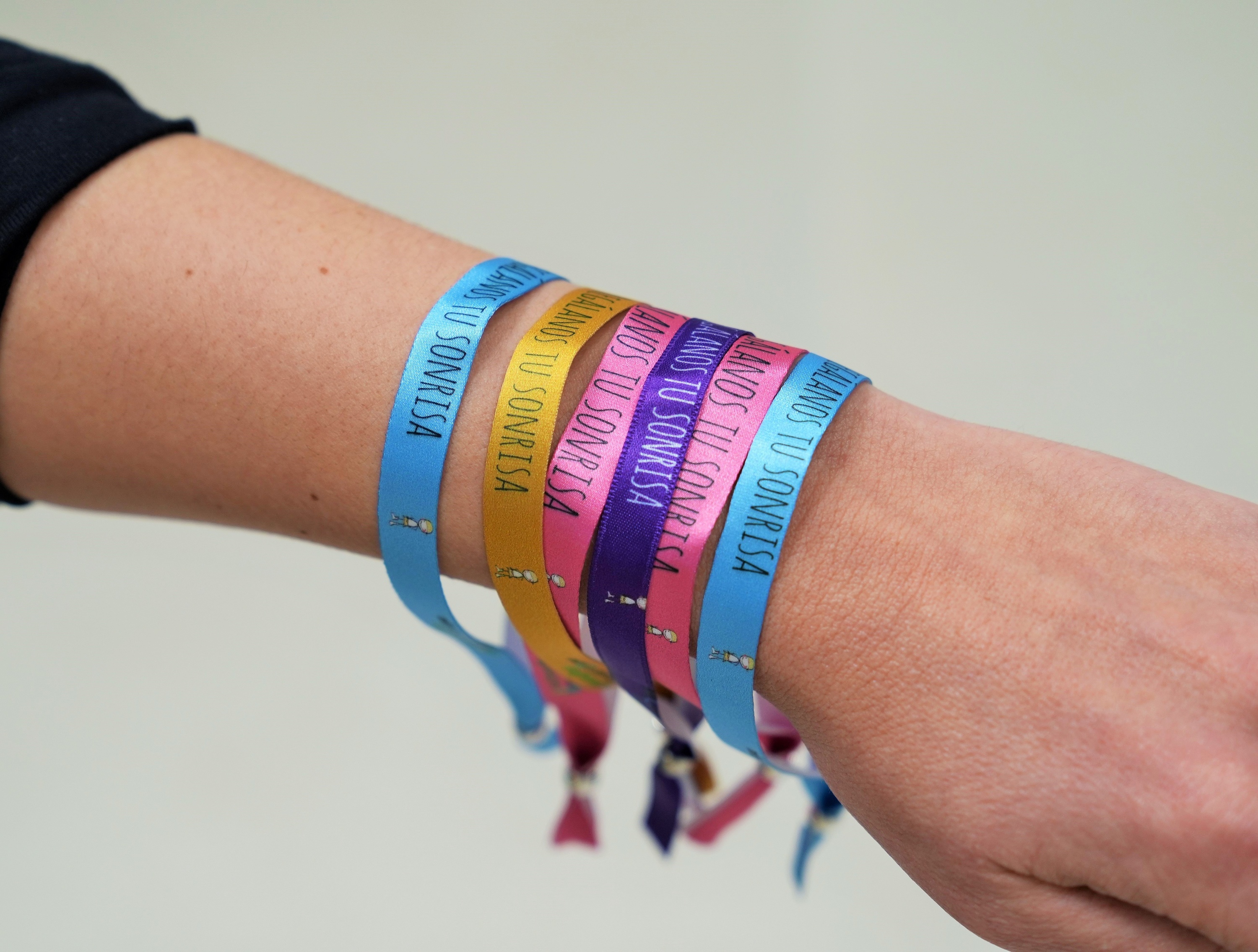 a bunch of bracelets with one that says sonrisa on it
