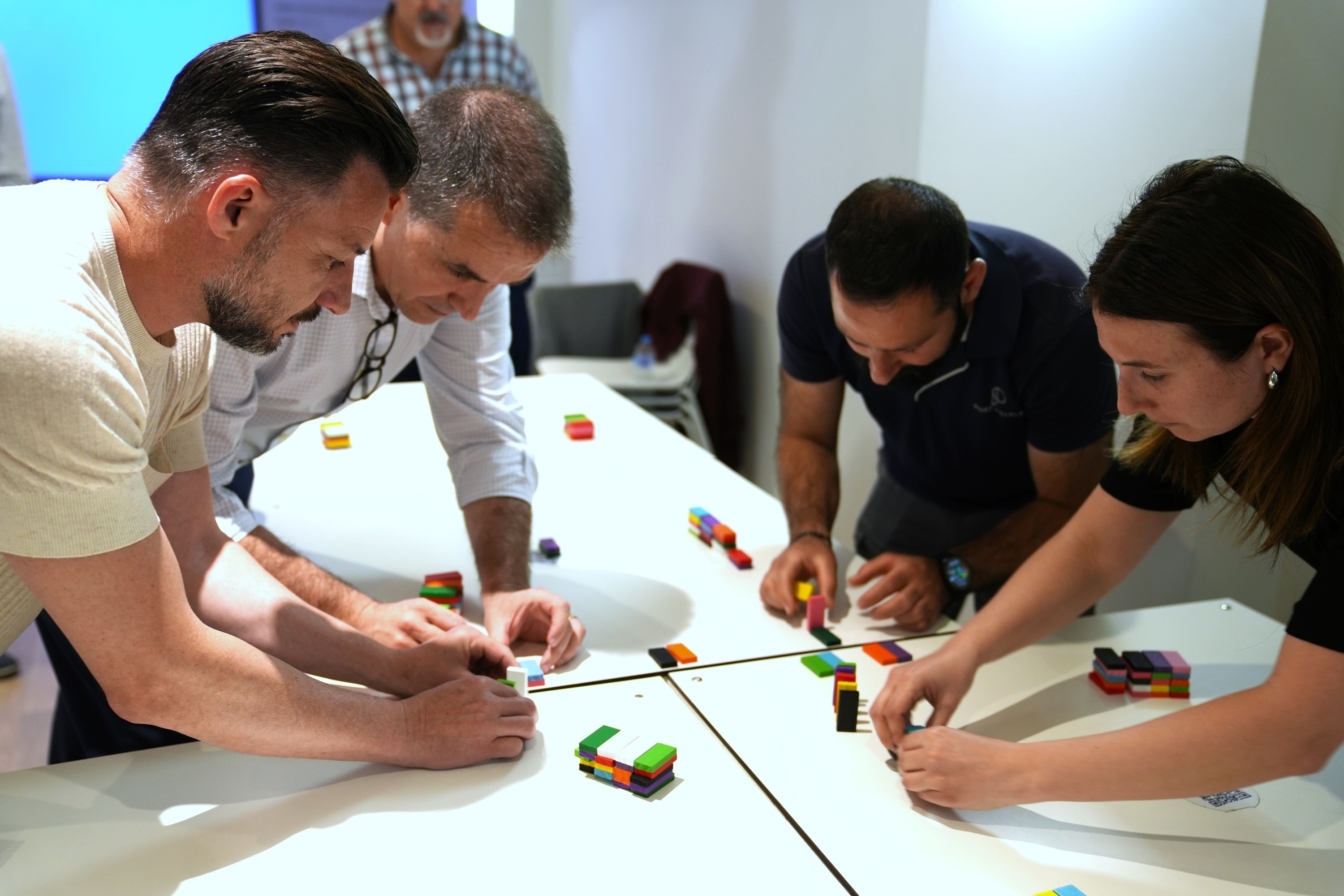 un grupo de personas están trabajando en una mesa con bloques de lego