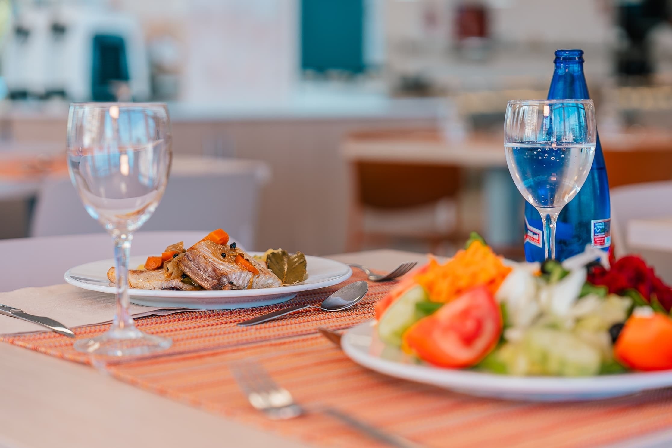 una mesa con un plato de comida y una botella de agua