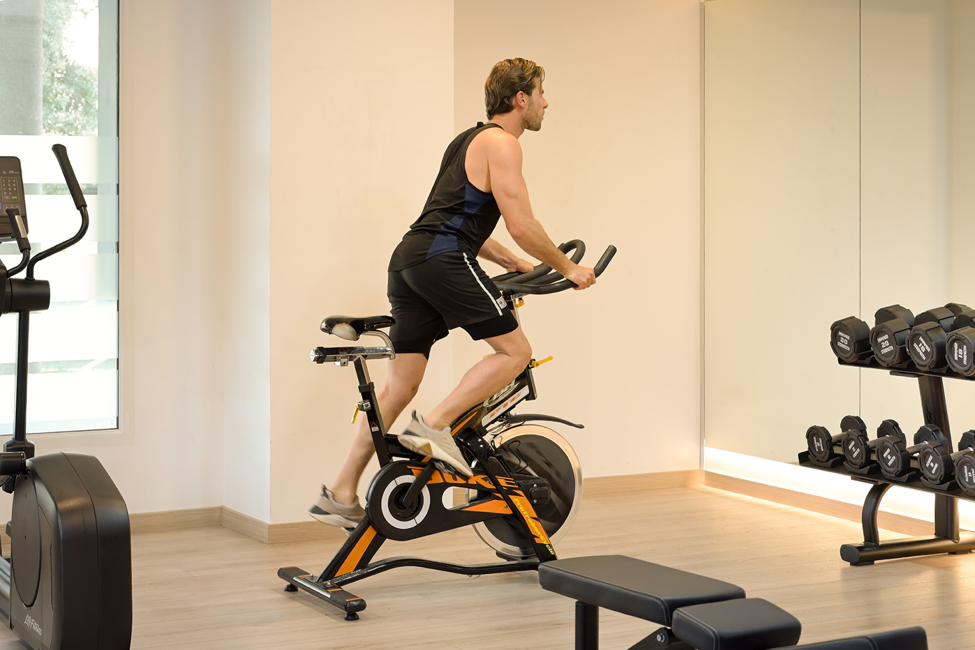un hombre monta una bicicleta de ejercicio en un gimnasio
