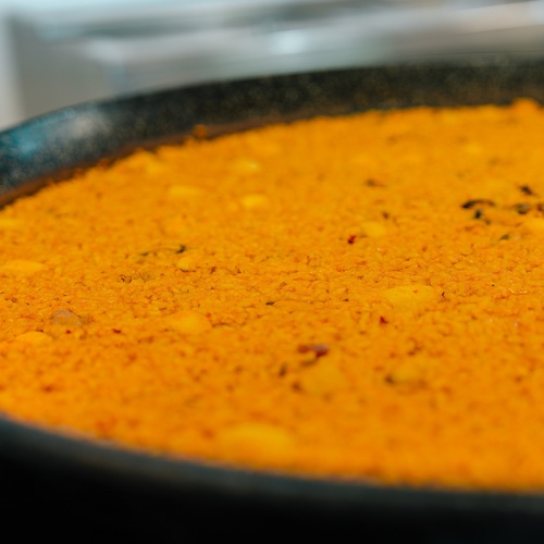 a pan filled with a thick orange colored rice