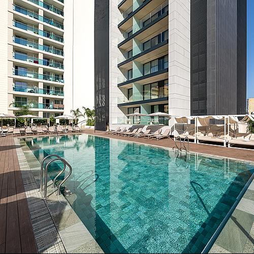 Amplia piscina y tumbonas en hotel moderno con vistas a Port Hotels: Corporativa.