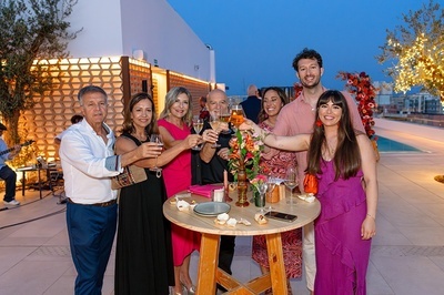 a group of people toasting with wine glasses at a table - 