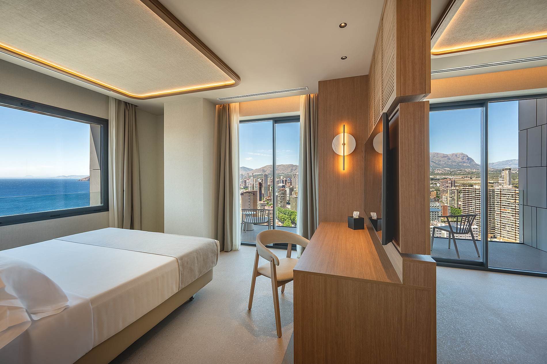 Dormitorio moderno con vista al mar y ciudad, cama doble, escritorio y silla. Port Benidorm Hotel & Spa | Alicante | Port Hotels | Web oficial.