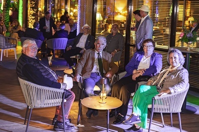 a group of people are sitting around a table - 