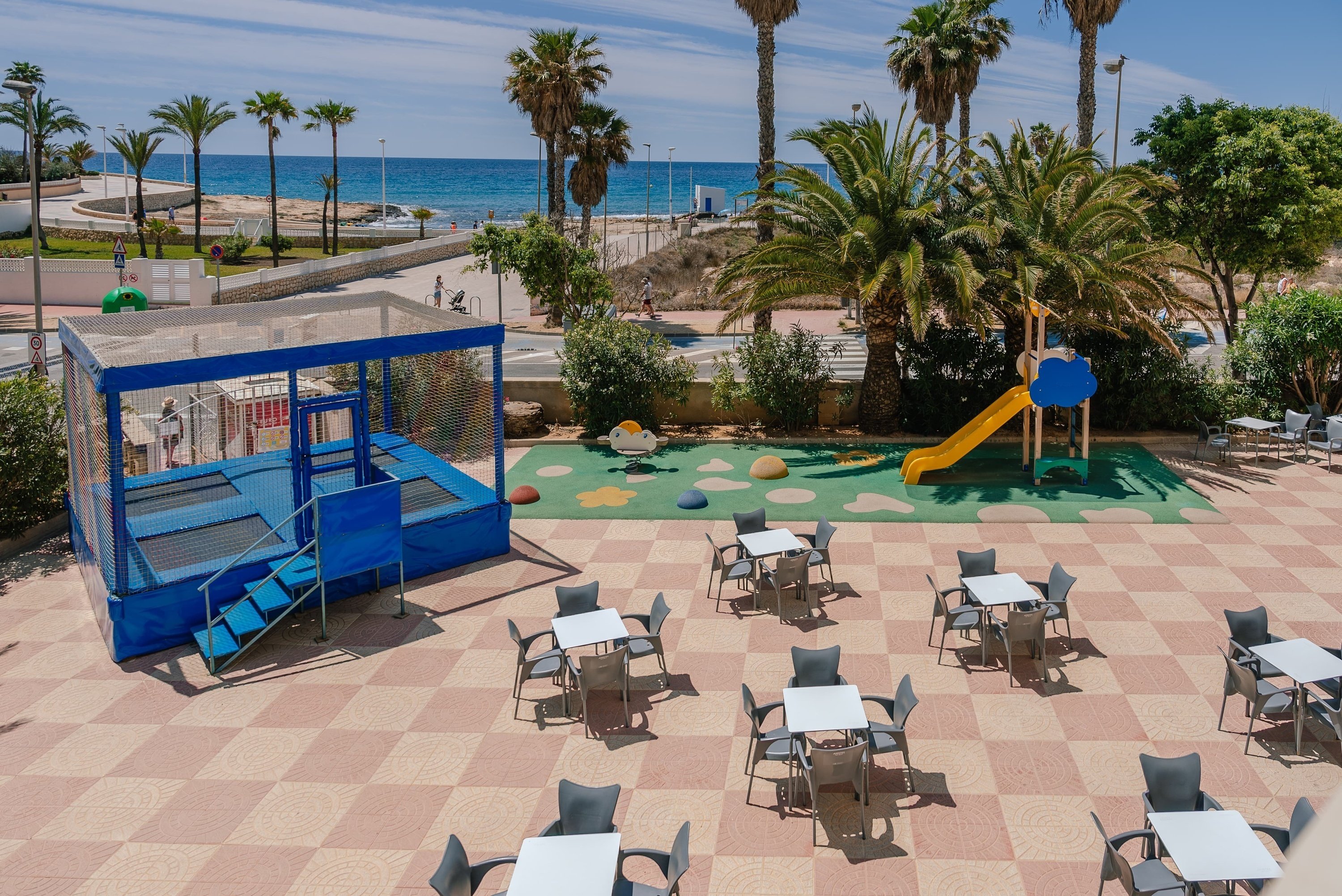 un patio con mesas y sillas y un trampolín