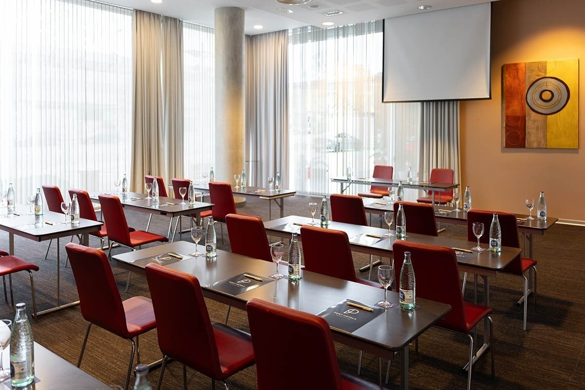 a conference room with tables and chairs and a projector screen