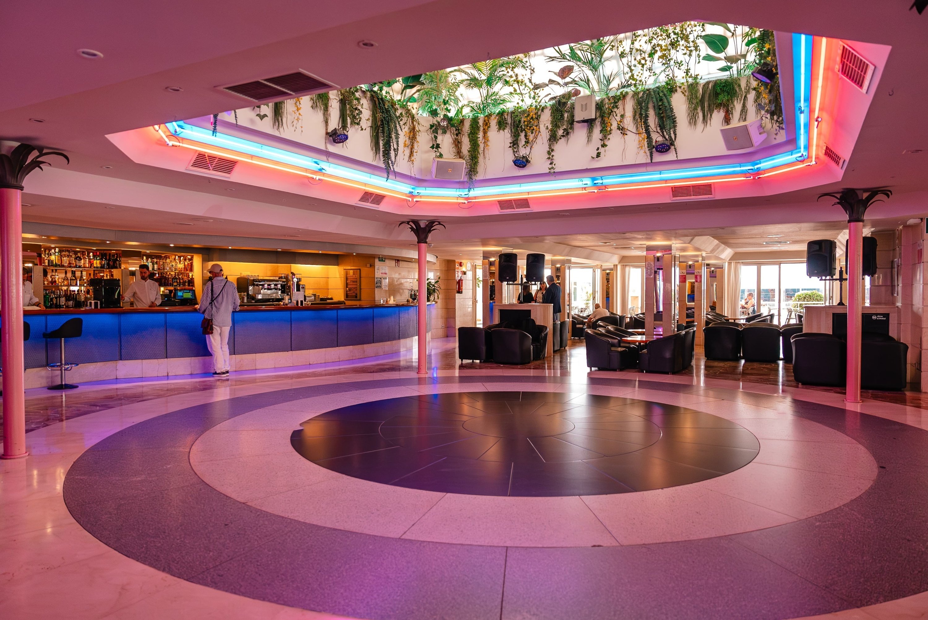 a man stands in front of a bar and a dance floor