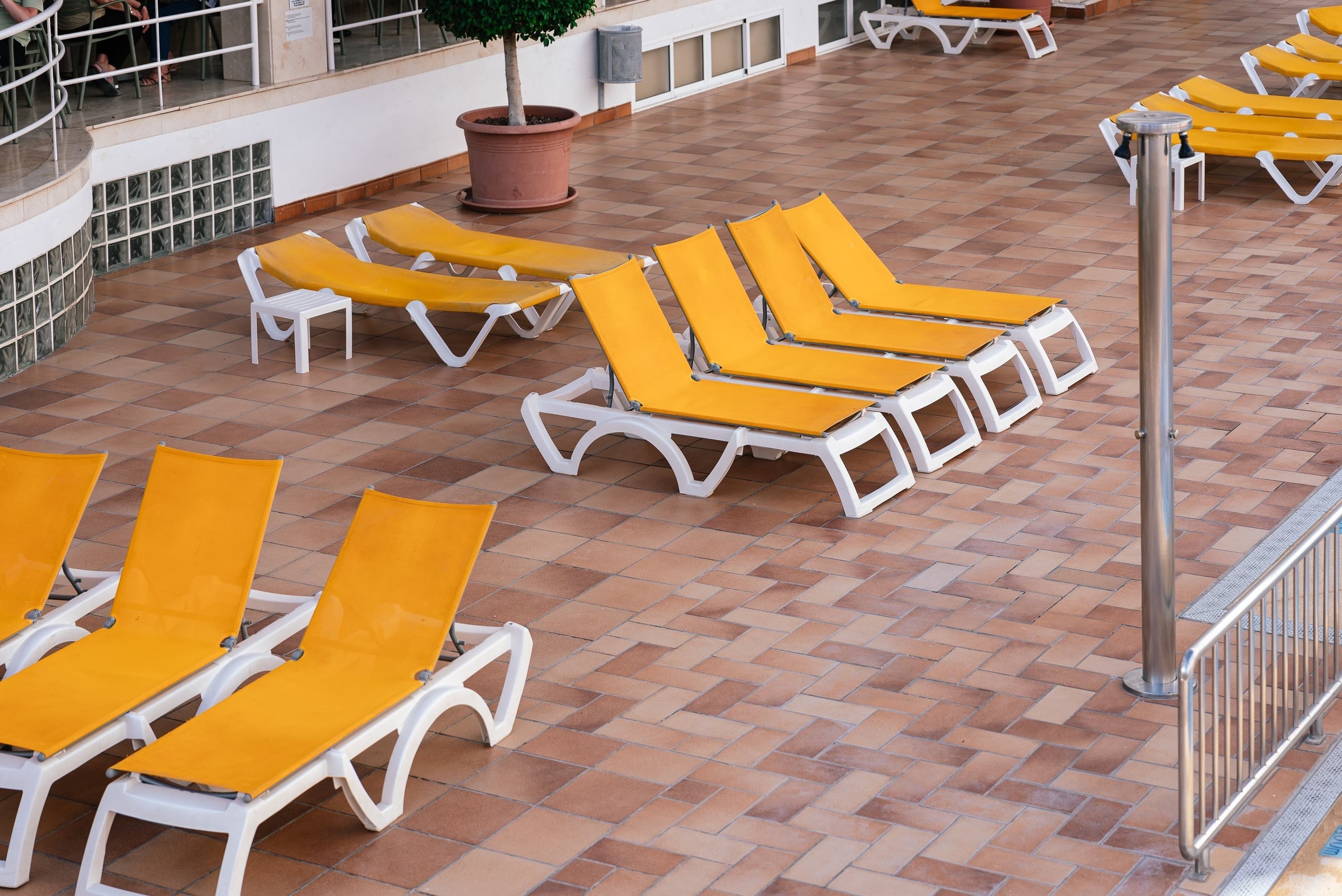 a row of yellow lounge chairs are lined up on a tiled floor