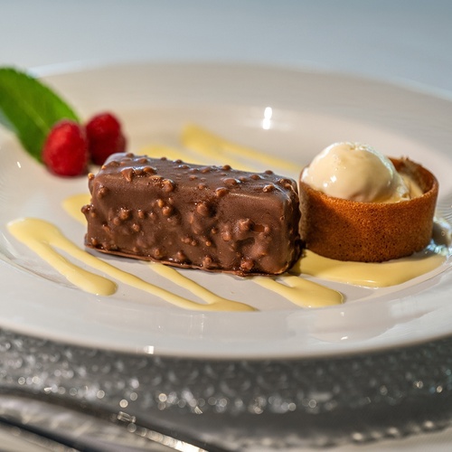 a white plate topped with a chocolate dessert and ice cream