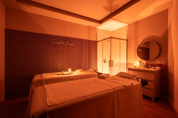 una mujer está dando un masaje a una persona con una botella de aceite