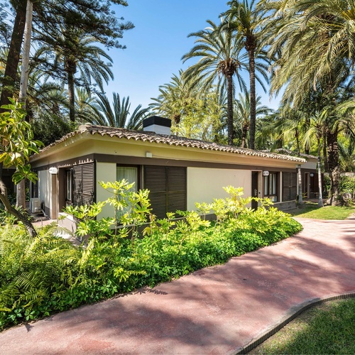 a small white house surrounded by palm trees