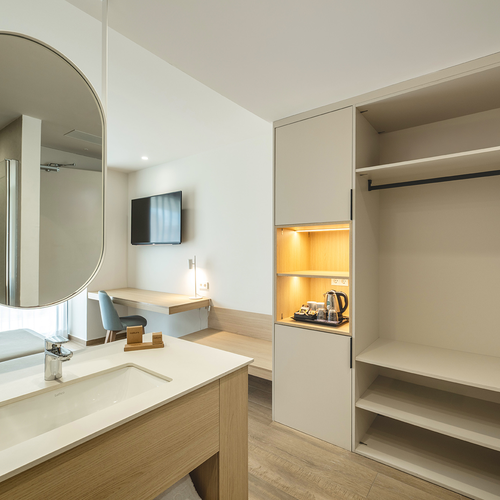 una habitación de hotel con un lavabo y un armario