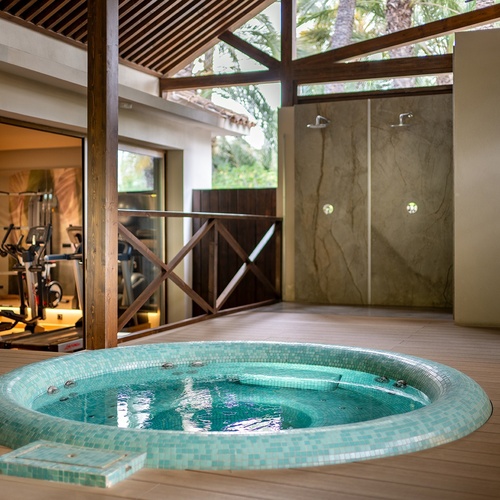 a jacuzzi in the middle of a room next to a gym