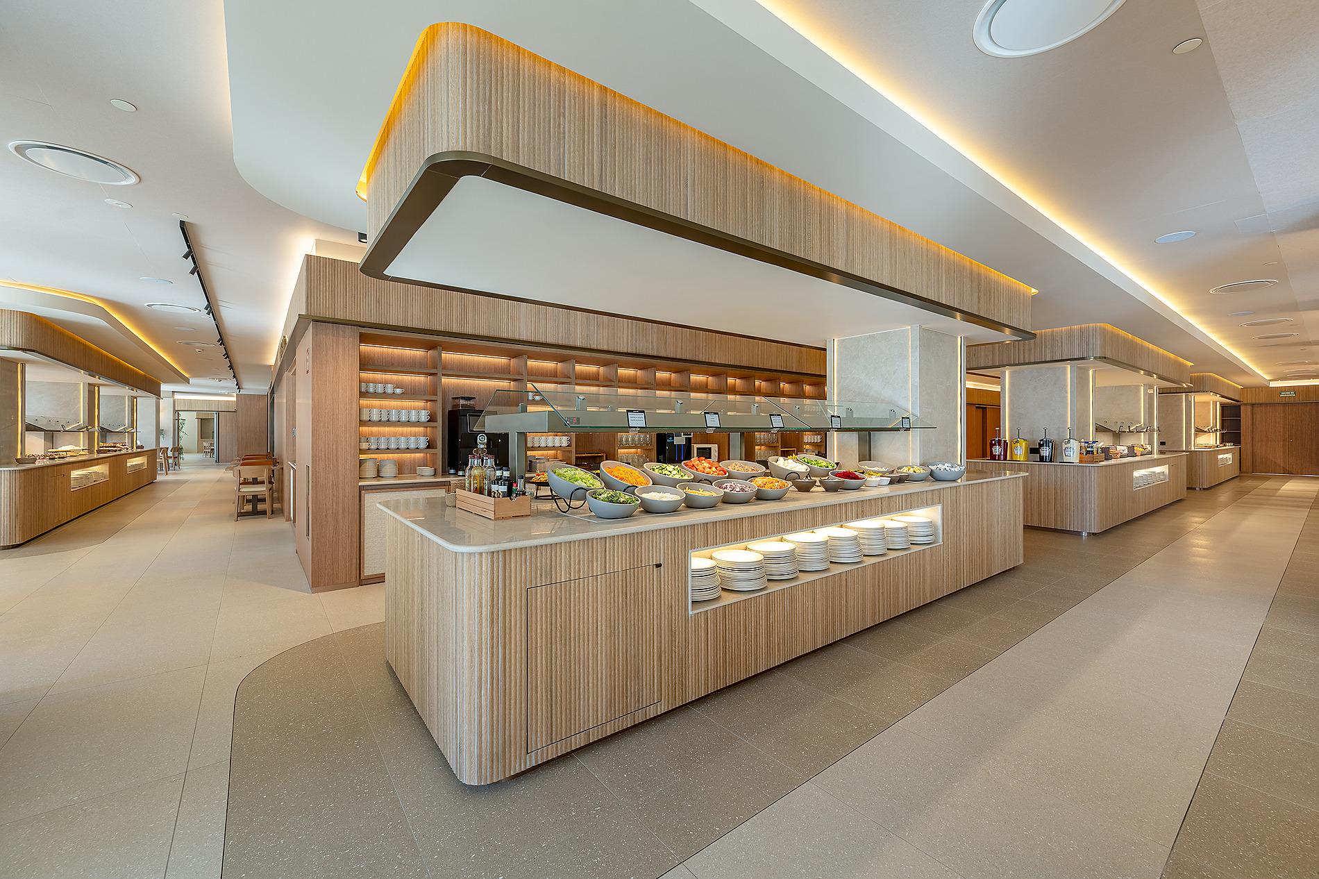 Buffet de hotel moderno con mesas de madera, iluminación tenue y opciones de comida fresca. Port Benidorm Hotel & Spa | Alicante | Port Hotels | Web oficial