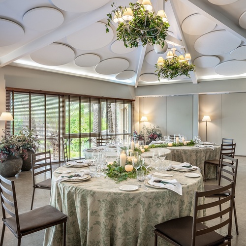 a room with tables and chairs and a chandelier hanging from the ceiling
