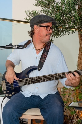 a man wearing a hat and glasses is playing a guitar - 