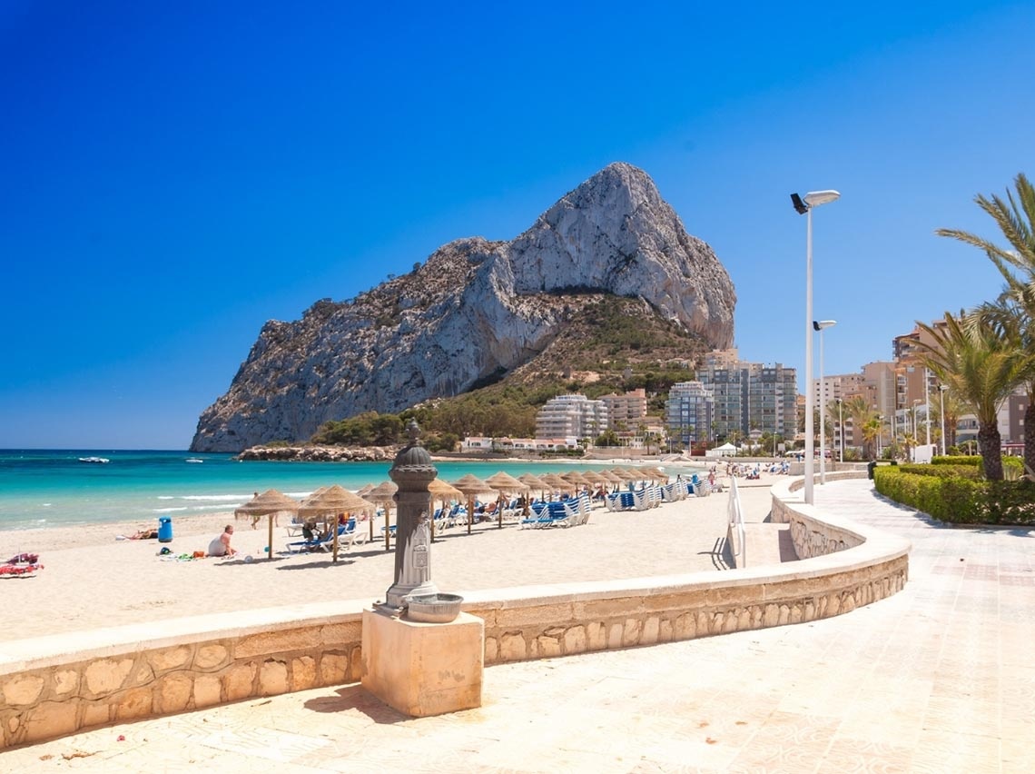 Port Hotels: Corporativa - Praia e Penha d'Ifac em Calp sob céu azul.