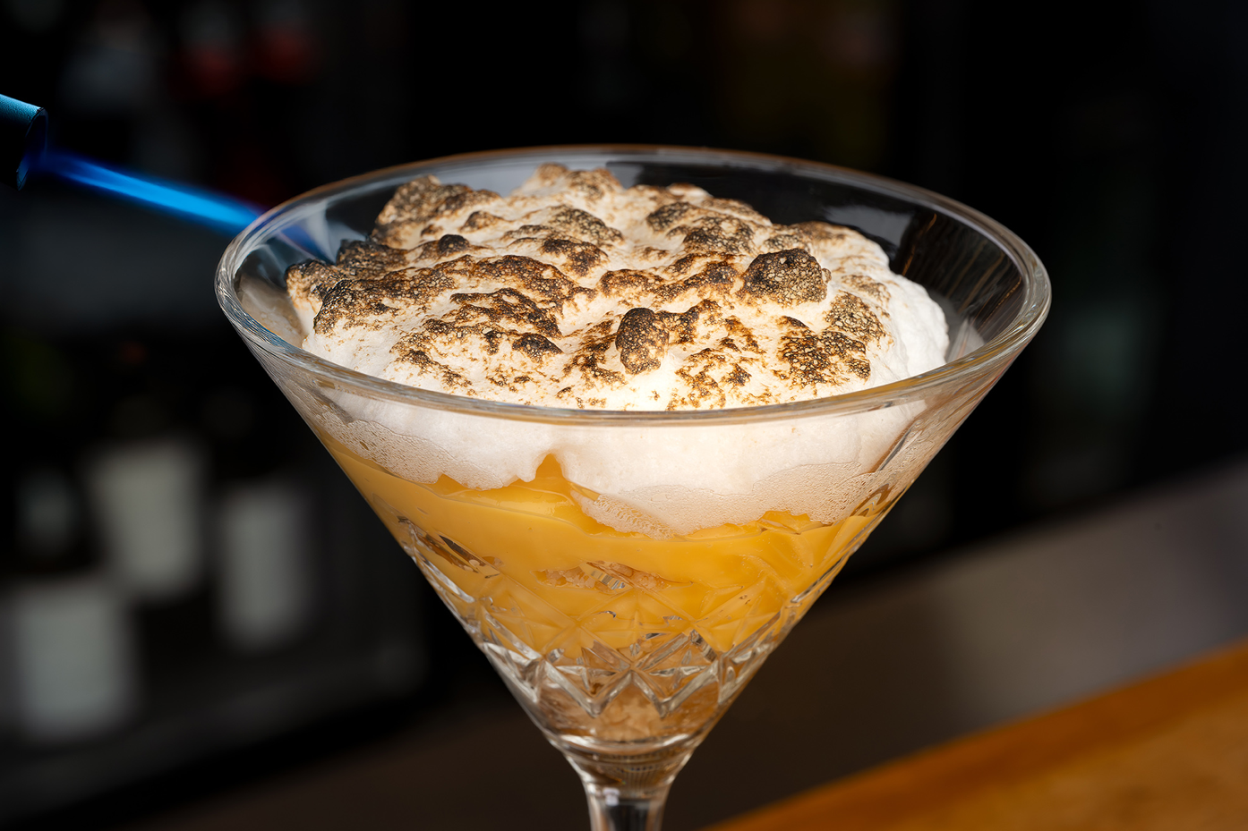 un cóctel en una copa de martini con merengue encima