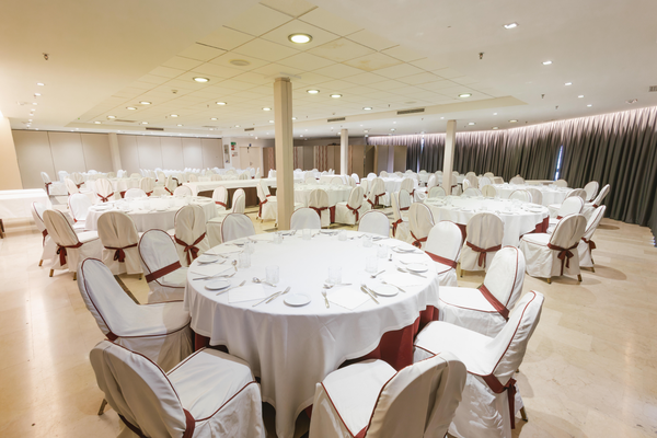 una sala de conferencias con mesas y sillas y una pantalla