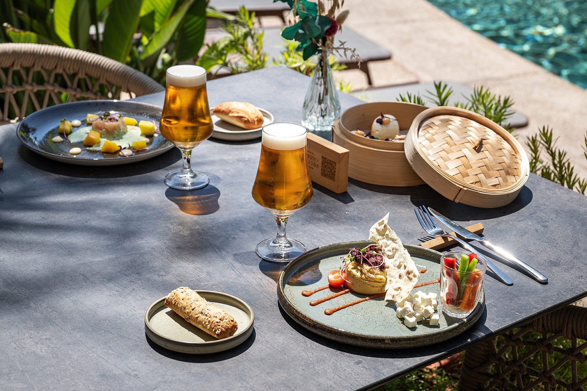 a table with plates of food and glasses of beer