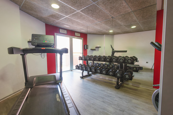 un gimnasio con mancuernas y una cinta de correr