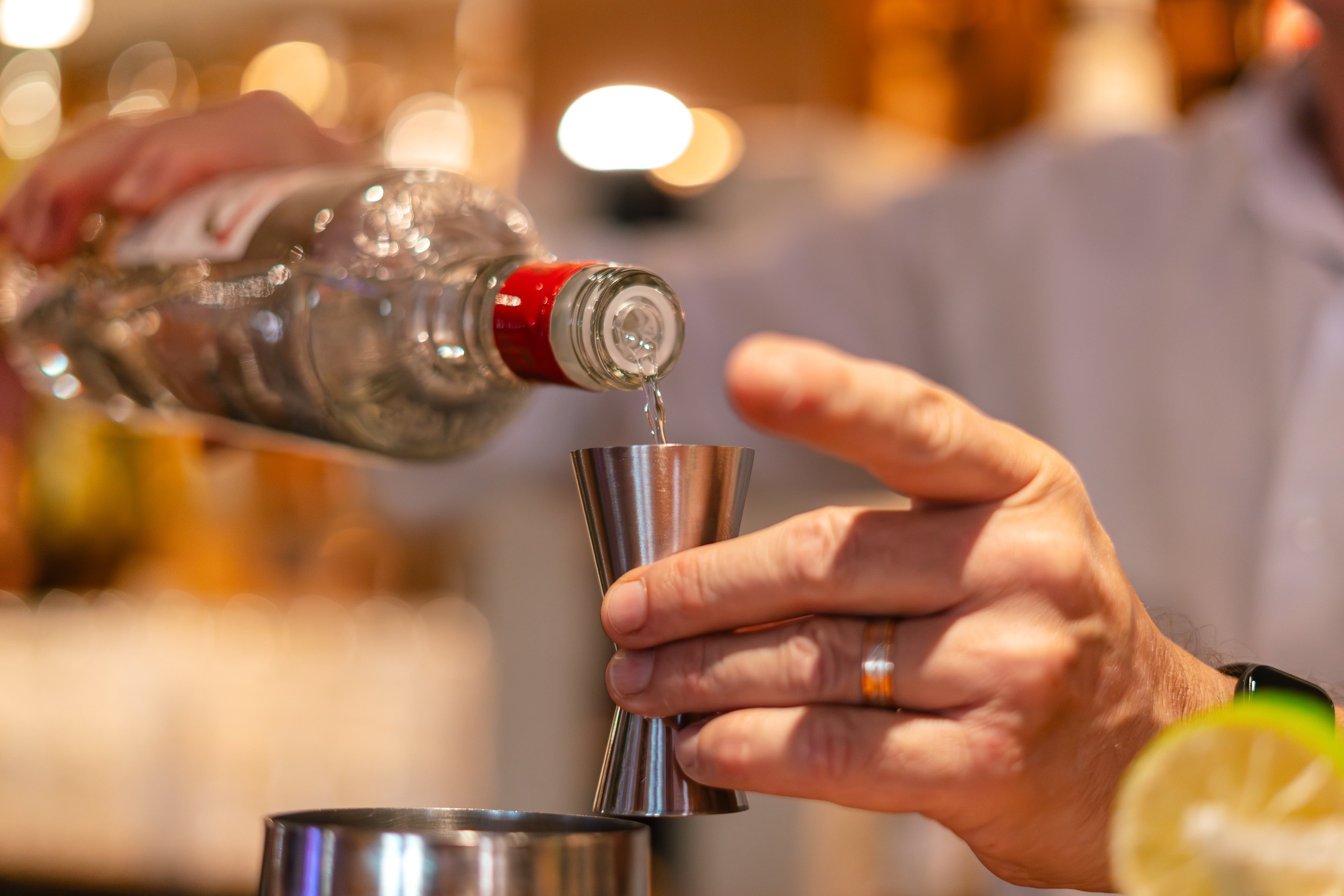 un barman vierte una bebida en un vaso de medición