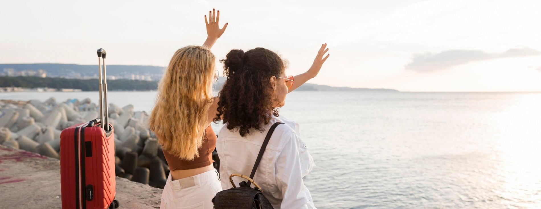 two women standing next to each other with their arms in the air