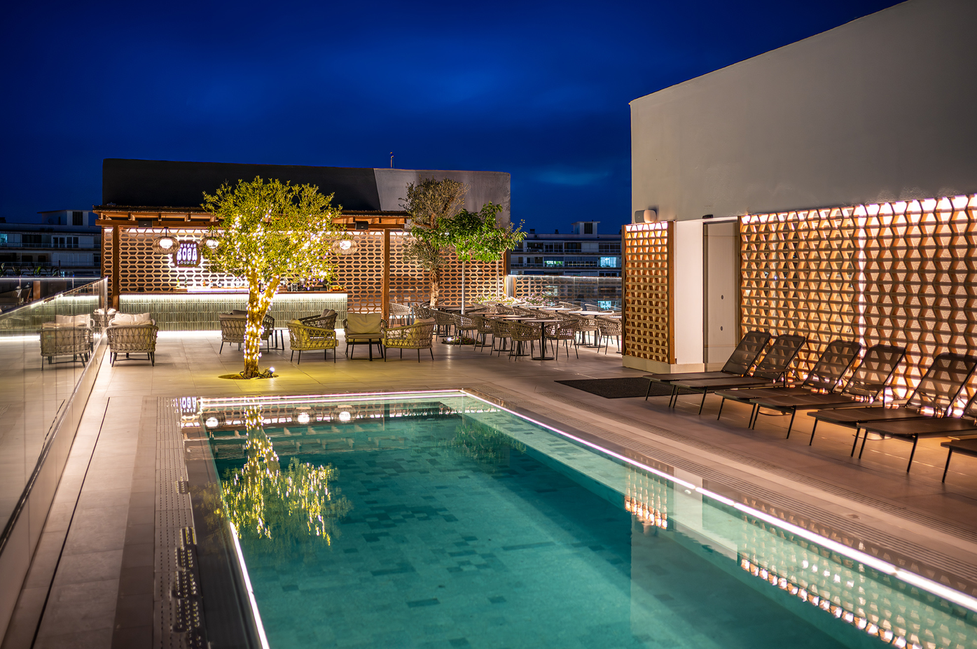 una piscina con sillas y mesas alrededor de ella