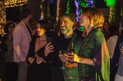 a man in a green suit holds a bottle of beer - 