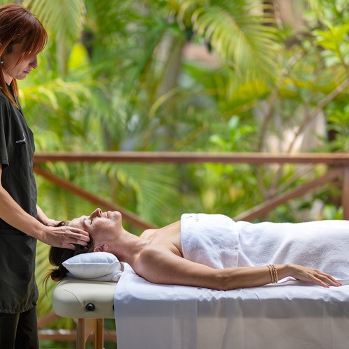 a woman laying on a table getting a head massage