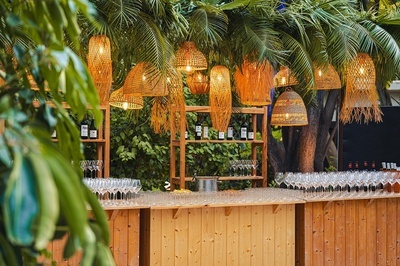 a wooden bar with bottles of wine and glasses on it - 